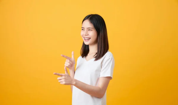 Sonriente Mujer Asiática Pie Señalando Dedo Sobre Fondo Naranja —  Fotos de Stock