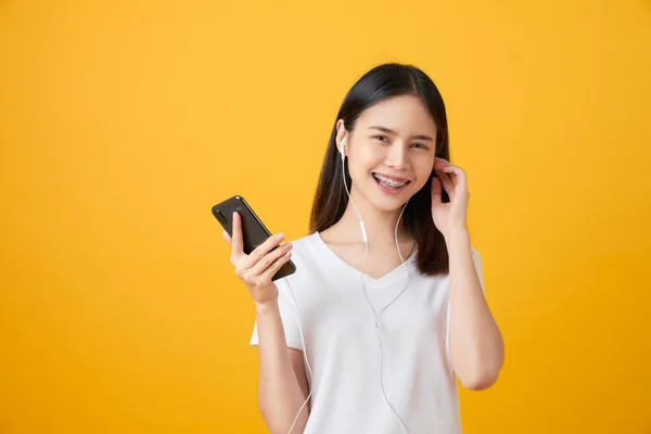 Mujer Asiática Feliz Sosteniendo Smartphone Escuchando Música Sobre Fondo Rosa — Foto de Stock