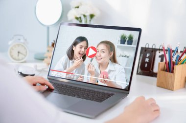 Genç Asyalı kadın vlogger videosu internette kozmetik ürünleri ve dizüstü bilgisayarında canlı video ile gösteriliyor. e-öğrenme kavramı.