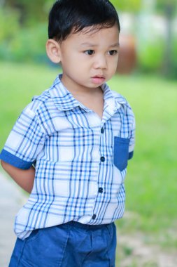 Öncesinde bakan çocuk ayakta gözler.