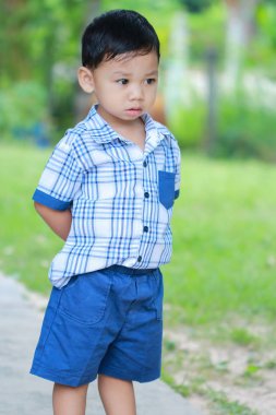 Öncesinde bakan çocuk ayakta gözler.