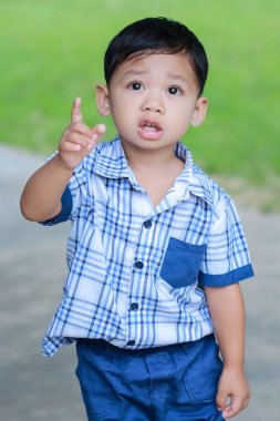 Öncesinde bakan çocuk ayakta gözler.