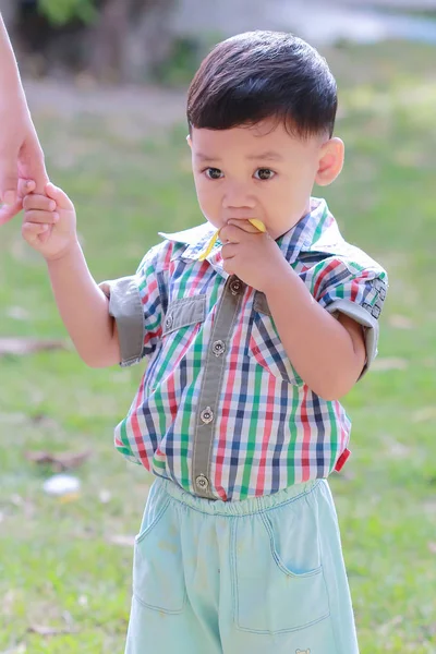 Precioso niño de pie comer plátanos — Foto de Stock