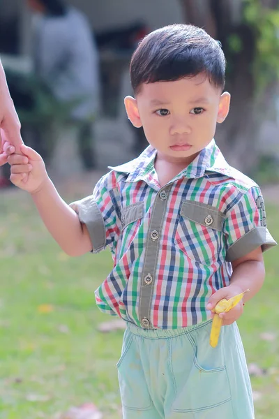 Precioso niño de pie comer plátanos — Foto de Stock