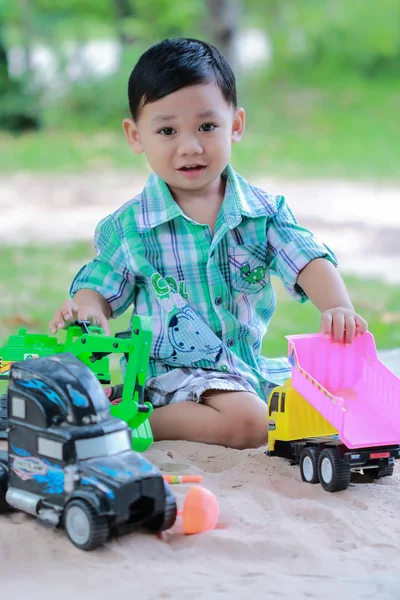 Little boy plays with toy car .