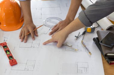 Planı üzerinde çalışan mimar. Mimarlar işyeri - mimari proje, planları, cetvel, hesap makinesi, laptop ve bölücü pusula. İnşaat kavramı. Mühendislik araçları. Üstten Görünüm