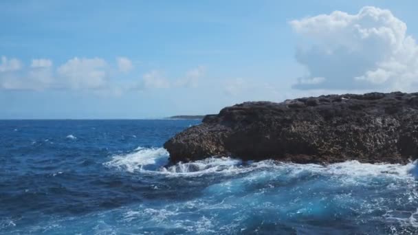 ターコイズブルーの海の岩の崖の海岸 波の泡と石の海岸でクラッシュします 美しい穏やかな背景自然の偉大さと力 — ストック動画