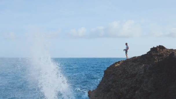 一个渔夫在岩石悬崖边旋转的钓竿上捕鱼 巨浪拍打在岩石上 大西洋 — 图库视频影像