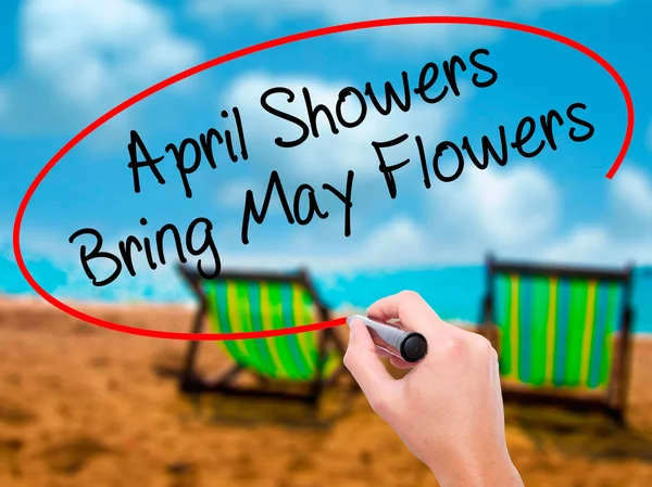 Человек рукой пишет April Showers Bring May Flowers with black mark — стоковое фото
