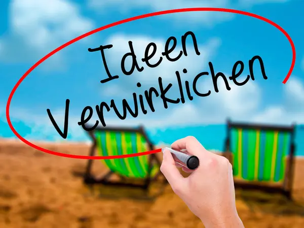 Muž ručně psaného textu Ideen Verwirklichen (realizovat myšlenky v němčině) — Stock fotografie