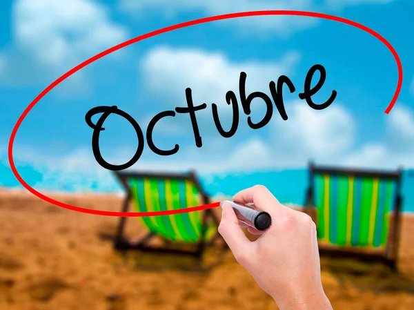 Man Hand writing & quot; Octubre & quot; (In Spanish: October) with — стоковое фото