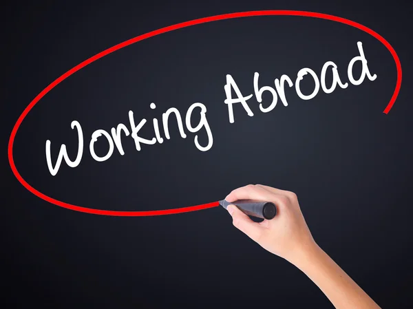 Woman Hand Writing Working Abroad with a marker over transparent — Stock Photo, Image