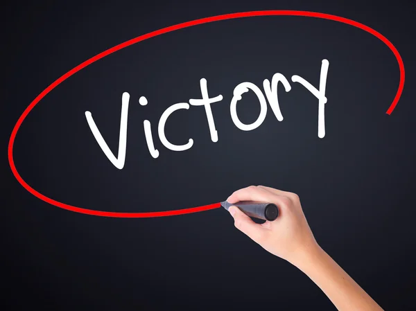 Woman Hand Writing Victory  with a marker over transparent board