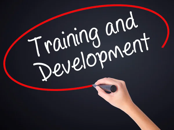 Woman Hand Writing Training and Development with a marker over t