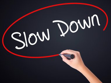 Kadın el yazma Slow Down şeffaf domuz üzerinde bir marker ile