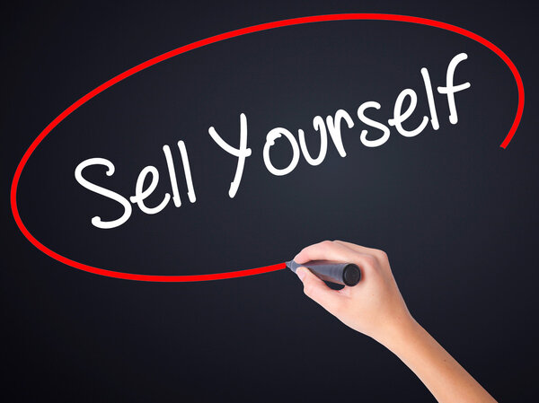 Woman Hand Writing Sell Yourself with a marker over transparent 