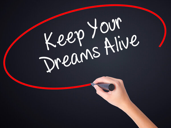 Woman Hand Writing Keep Your Dreams Alive with a marker over tra