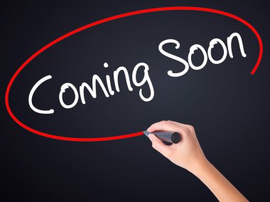 Kadın el yazma Coming Soon şeffaf bo üzerinde bir marker ile
