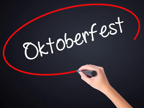 Ženská ruka psaní Oktoberfest fixou přes transparentní bo — Stock fotografie