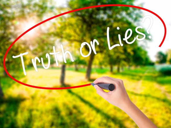 Vrouw Hand schrijven Truth or Lies? met een marker over transparant — Stockfoto
