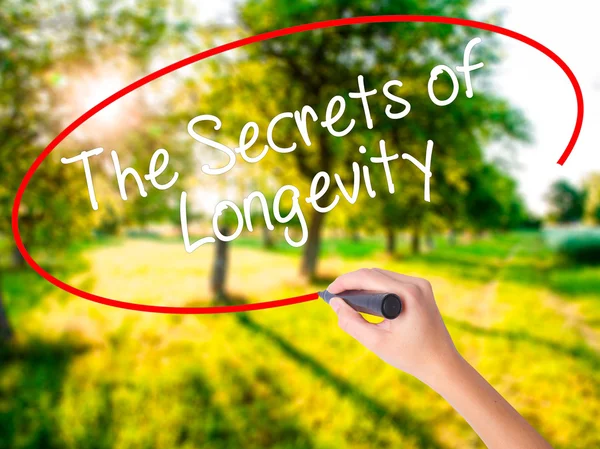 Femme écriture à la main Les secrets de la longévité avec un marqueur sur t — Photo