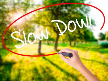 Kadın el yazma Slow Down şeffaf domuz üzerinde bir marker ile