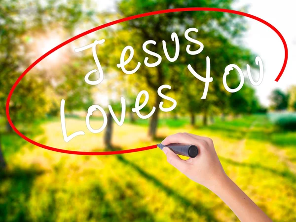 Ženská ruka psaní Ježíš vás miluje fixou přes průhledné — Stock fotografie