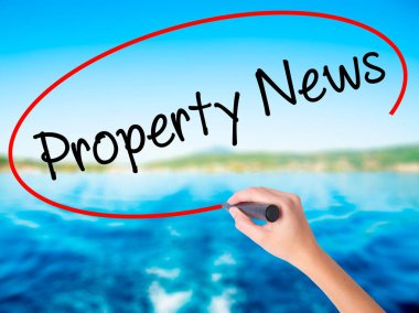 Kadın el yazma Emlak haberleri üzerine saydam bir marker ile 