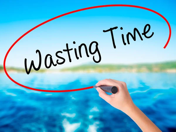 Woman Hand Writing Wasting Time with a marker over transparent b — Stock Photo, Image