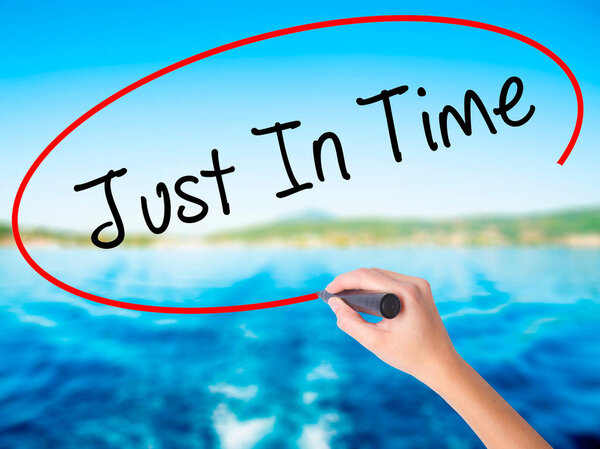 Woman Hand Writing Just In Time with a marker over transparent b