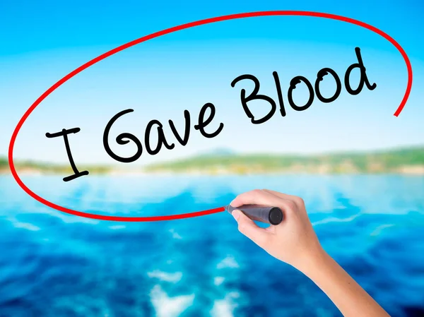 Kvinna Hand skriver jag gav blod med en markör över transparent b — Stockfoto