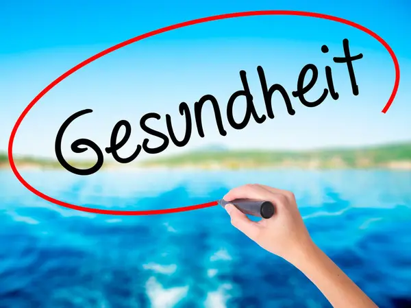 Ženská ruka psaní Gesundheit (zdraví v němčině) značkou — Stock fotografie