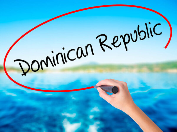 Женщина пишет вручную Доминиканскую Республику с маркером над транспарантом
