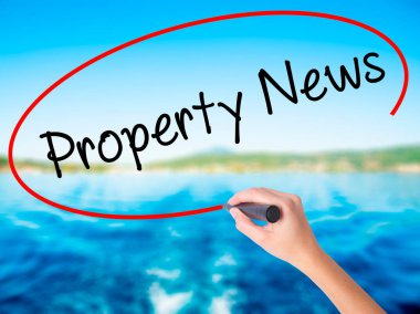 Kadın el yazma Emlak haberleri üzerine saydam bir marker ile 