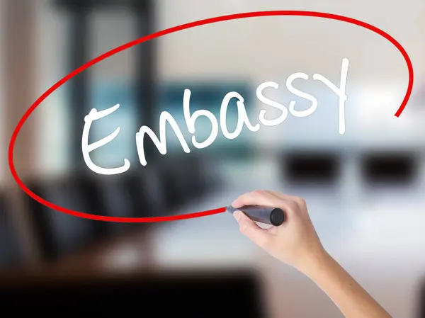 stock image Woman Hand Writing Embassy with a marker over transparent board