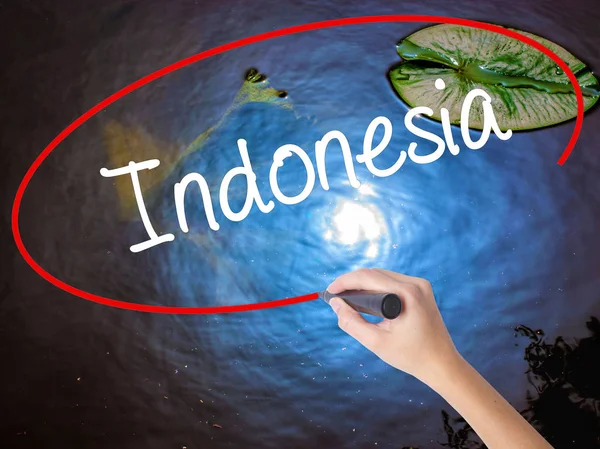 Kvinna Hand skrivande Indonesien med markör över transparent styrelse — Stockfoto
