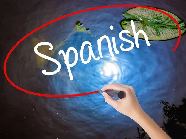 女人的手写作西班牙语在透明板标记 — 图库照片