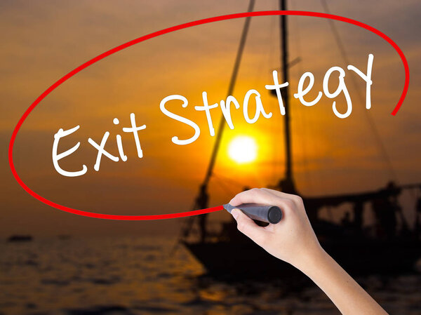 Woman Hand Writing Exit Strategy with a marker over transparent 
