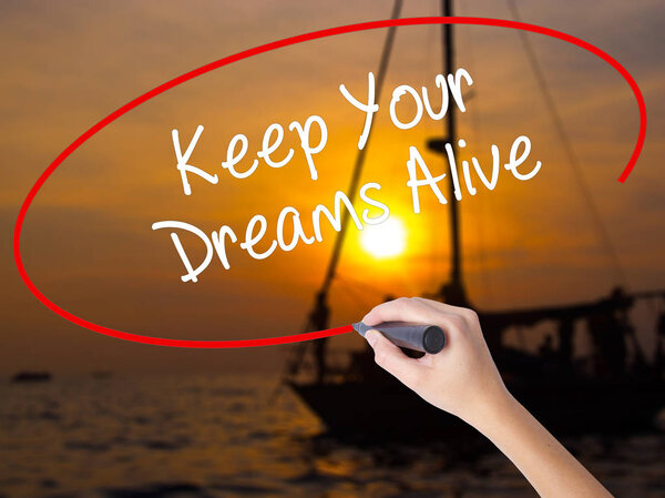Woman Hand Writing Keep Your Dreams Alive with a marker over tra
