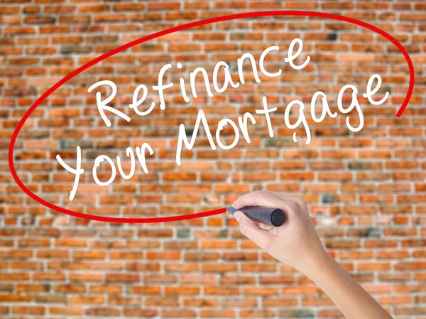 Woman Hand Writing Refinance Your Mortgage with black marker on
