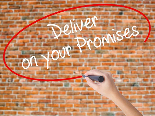 Woman Hand Writing Deliver on your Promises with black marker on