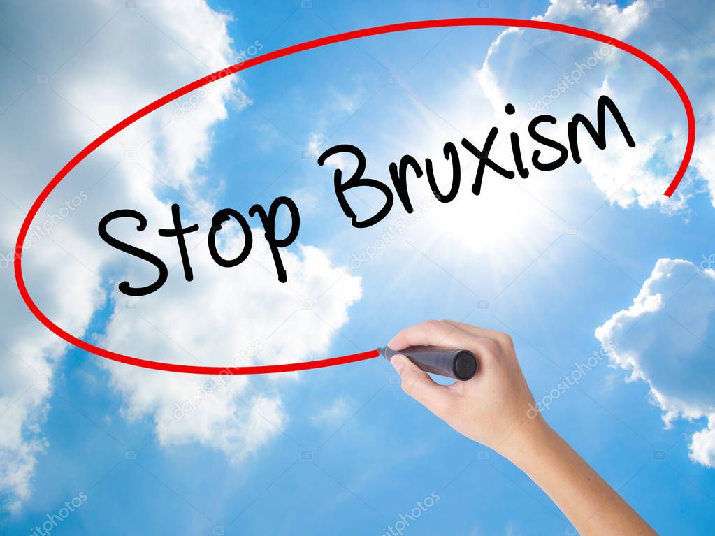 Woman Hand Writing Stop Bruxism with black marker on visual scre