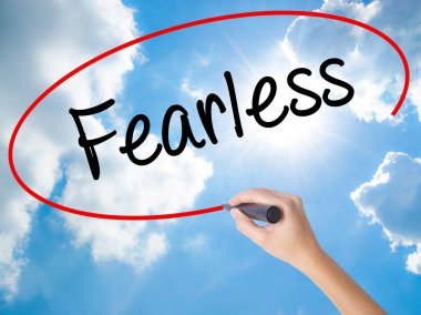 Woman Hand Writing Fearless with black marker on visual screen. clipart