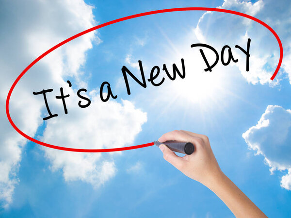 Woman Hand Writing It's a New Day with black marker on visual sc