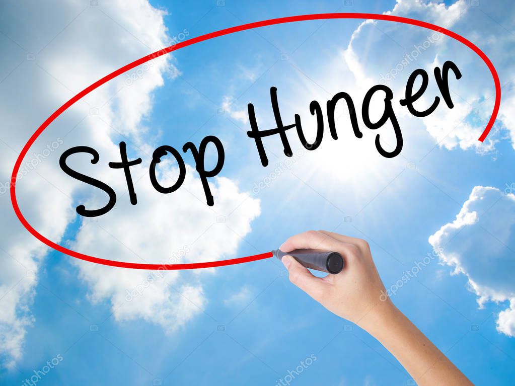 Woman Hand Writing  Stop Hunger with black marker on visual scre