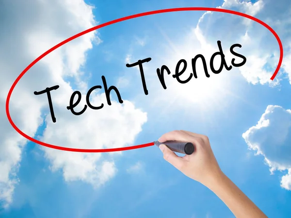 Woman Hand Writing Tech Trends with black marker on visual scree