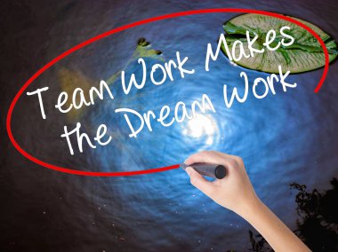 Woman Hand Writing Team Work Makes the Dream Work with marker ov clipart