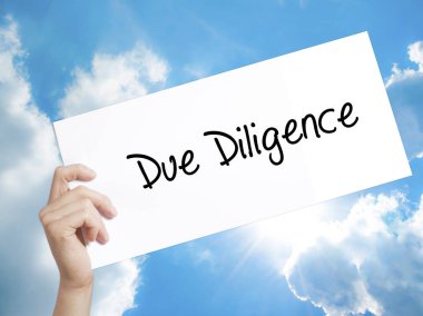 Due Diligence işareti beyaz kağıt üzerinde. Adam el kağıt t ile tutarak