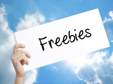 Freebies Sign on white paper. Man Hand Holding Paper with text.  clipart