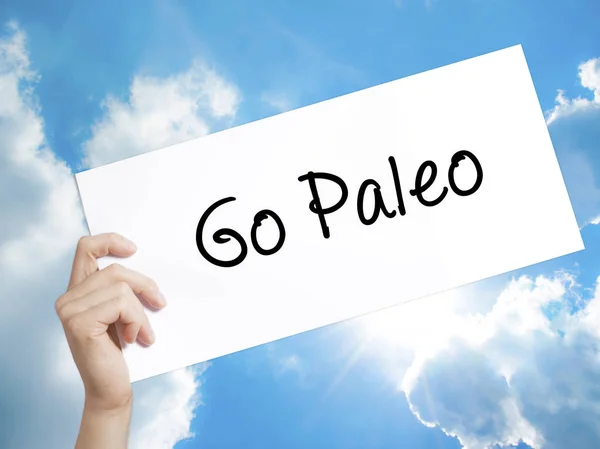 Go Paleo Sign on white paper. Man Hand Holding Paper with text.